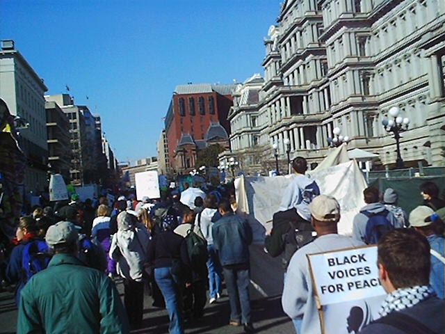 Marchers on the street with Snipers on top of the red building